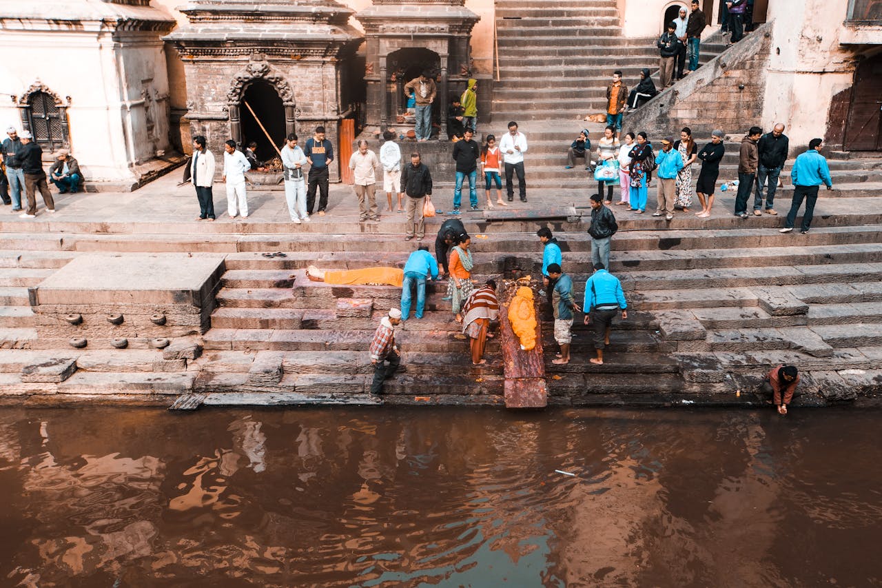 People Standing on Concrete Stairs Near Water